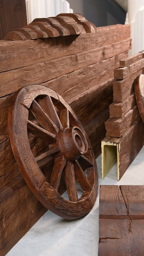 Un dettaglio inclinato mette in risalto le texture rustiche delle tavole intorno a un grande ornamento a forma di ruota
