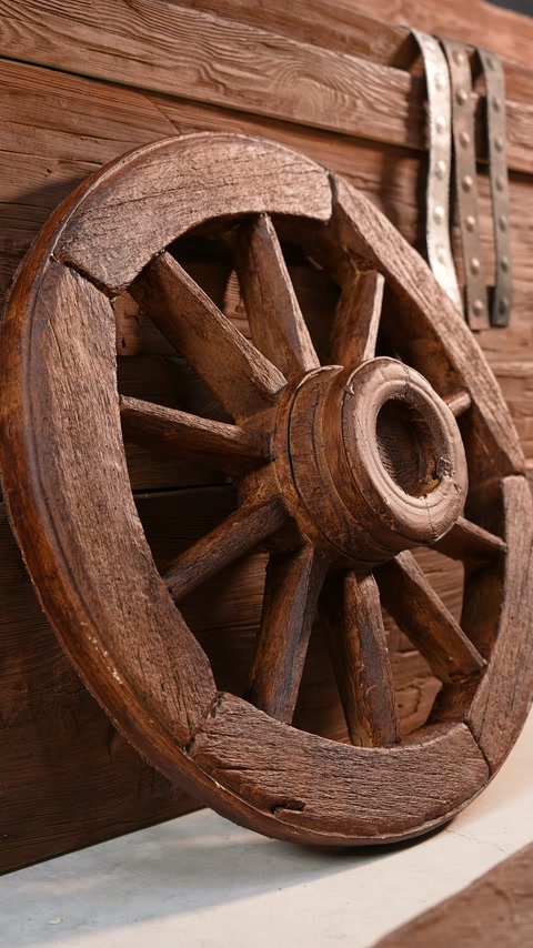 Un ornamento dettagliato a forma di ruota mostra raggi intagliati davanti a tavole stratificate effetto legno