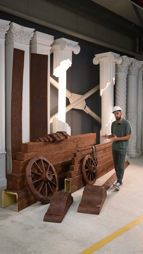 Il presentatore torna accanto a profili di travi impilati nello showroom architettonico