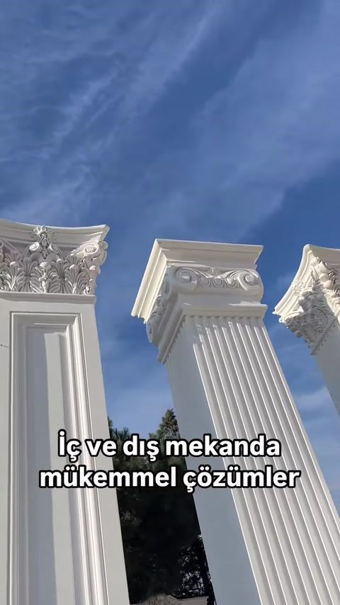 Capitelli di colonne decorati con diversi motivi sono visibili contro il cielo