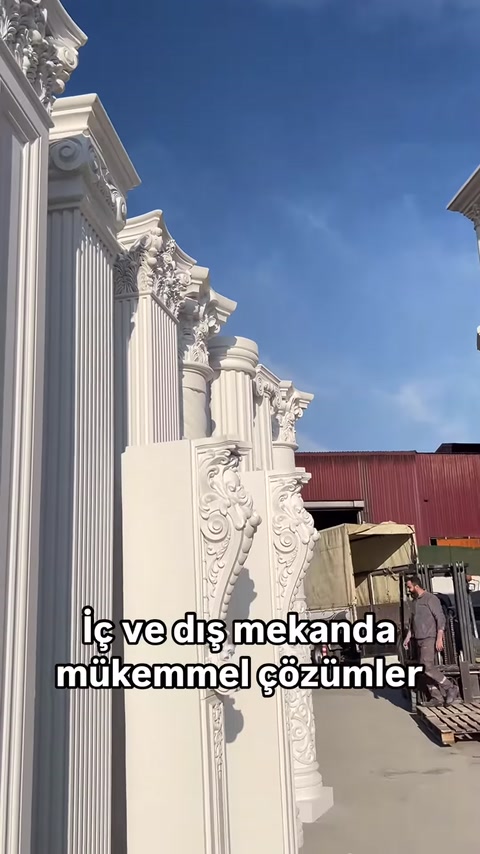 Tra le colonne si vede il dettaglio di un elemento verticale decorativo con motivo vegetale