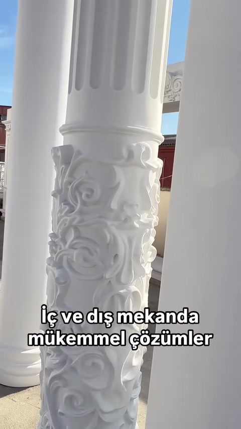Si vede in primo piano il dettaglio di un fusto di colonna con motivi a foglia in rilievo