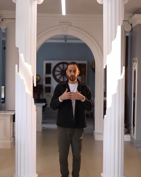 Presenter standing between illuminated columns closing the video