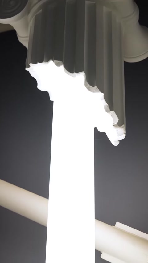 Detail shot of column crown with warm LED light emerging from crevice