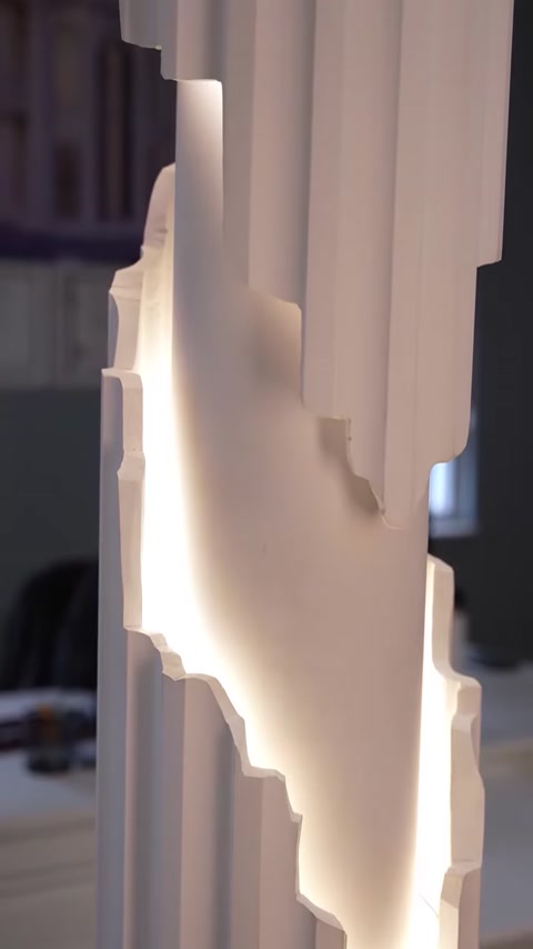Textured column surface glowing softly from concealed LED strip