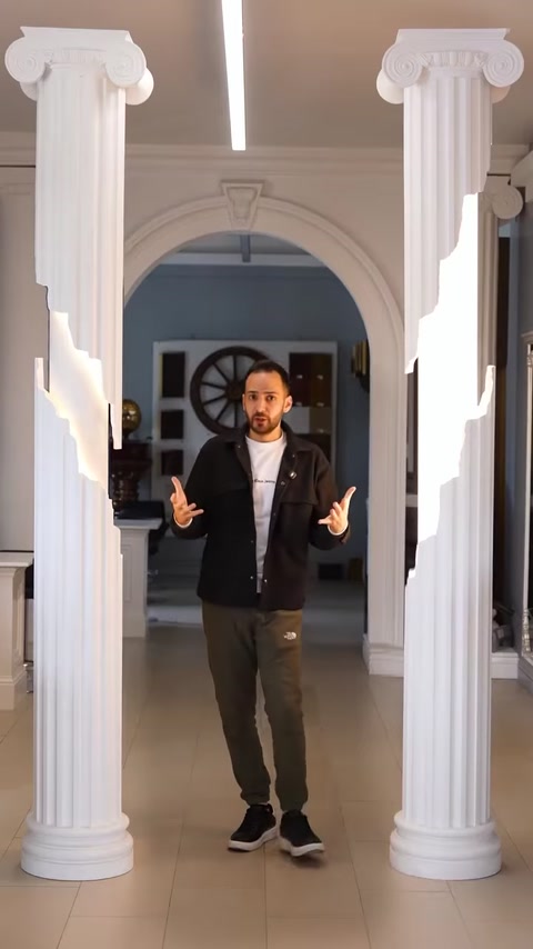 Man explaining column lighting options in showroom hallway