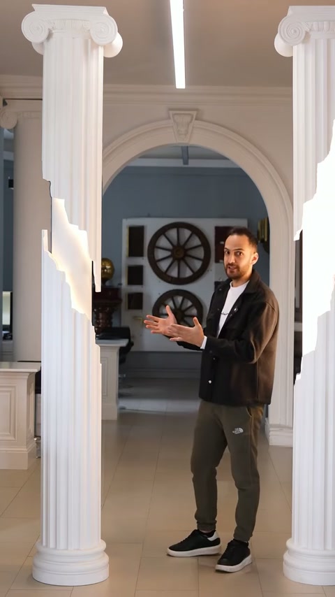 Presenter discusses paired fluted columns framing an arched showroom entrance.