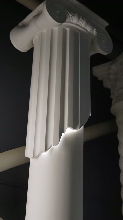 Tall fluted column section transitions into a softly glowing smooth panel.