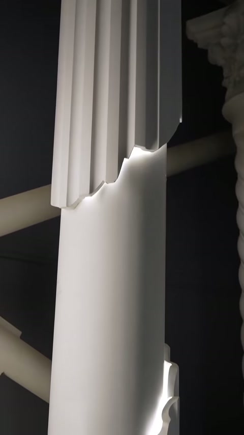 Illuminated seam highlights where fluted molding meets the smooth column surface.