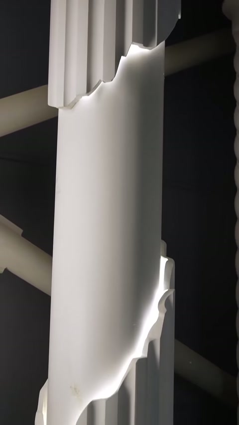 Smooth column panel emits edge lighting below the upper fluted section.