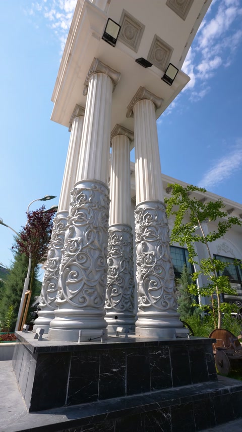 Arch base displaying fluted column shafts and densely embossed pedestals.