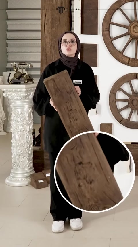 La texture superficiale e i nodi effetto legno di una trave in poliuretano sono mostrati in primo piano