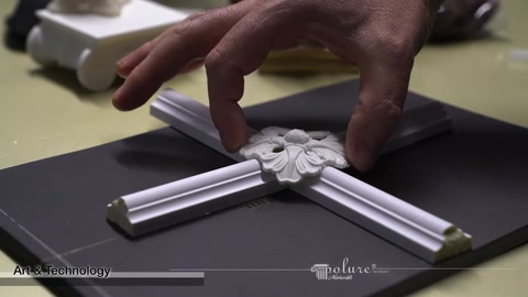 Un ornamento centrale con motivo floreale viene posizionato sulle modanature incrociate