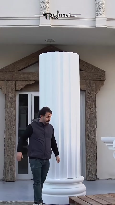 A fluted decorative column shaft stands upright in front of the facade