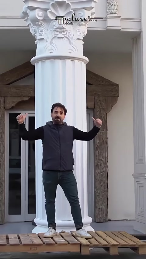 A completed fluted Corinthian column is presented in front of an exterior facade