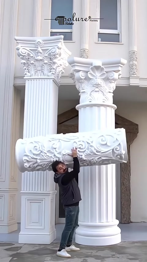 A cylindrical patterned column base is raised toward the shaft