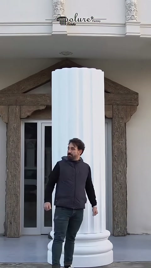 L'artigiano ispeziona il fusto verticale della colonna di fronte alla facciata