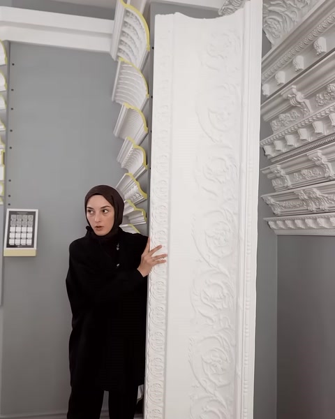 Desenli dikey profil showroomdaki kartonpiyer örnekleri yanında inceleniyor