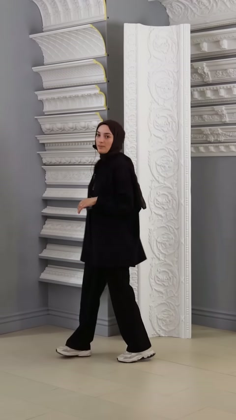 Sunucu, farklı biçimlerdeki kartonpiyerlerin önünde ürünleri açıklıyor.