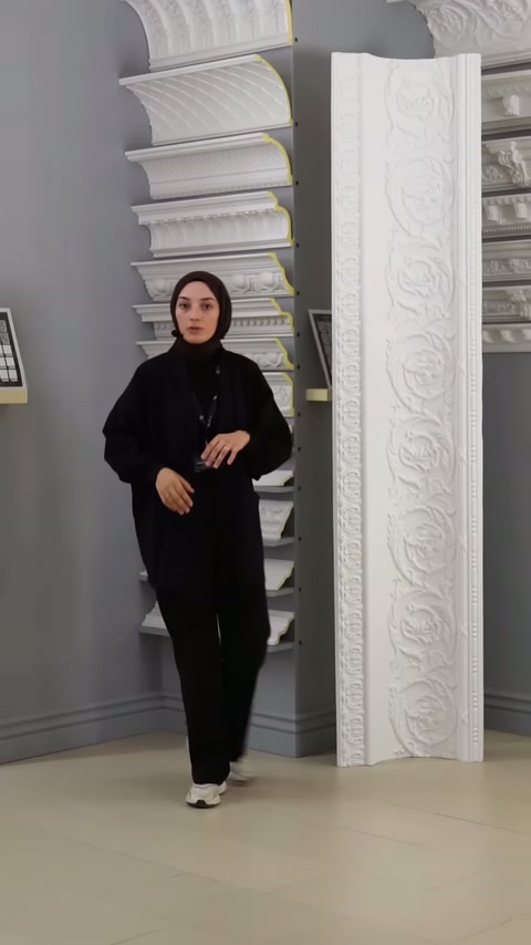 Sunucu, showroom köşesindeki kartonpiyer çeşitlerinin yanında bilgi veriyor.