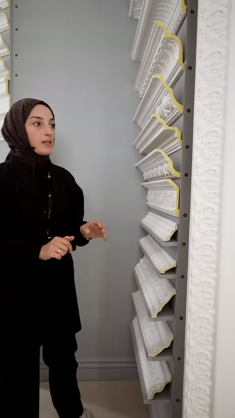 Sunucu, kartonpiyer raflarının yanındaki kabartmalı uzun paneli anlatıyor.