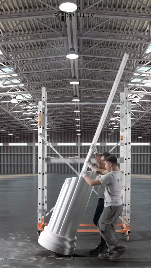 Due operai solevano il lungo elemento della colonna sulla base scanalata.