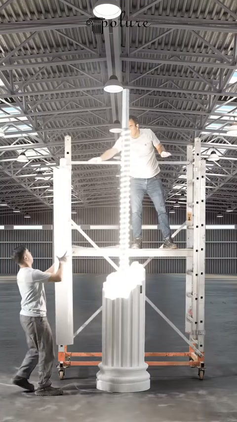 Un lungo pezzo di rivestimento bianco si avvicina al corpo della colonna illuminato.