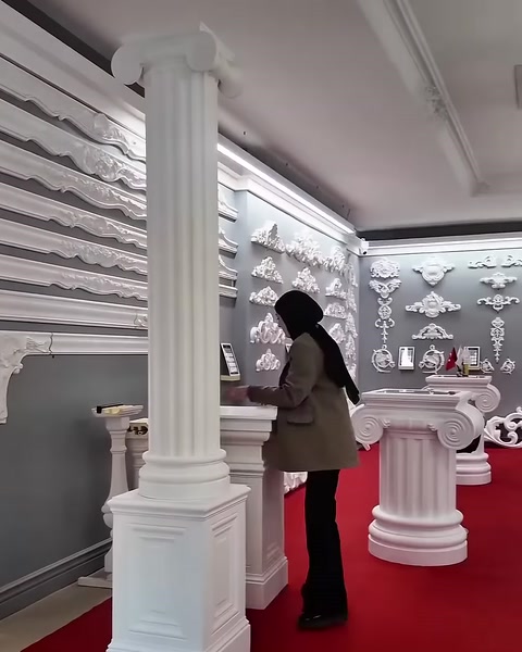 A fluted column with a square base is presented in front of the showroom wall