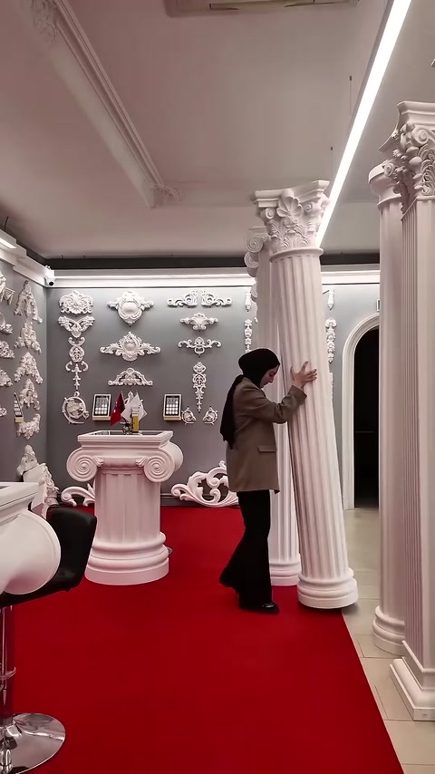 L'addetto esamina da vicino la superficie della colonna scanalata lunga in showroom