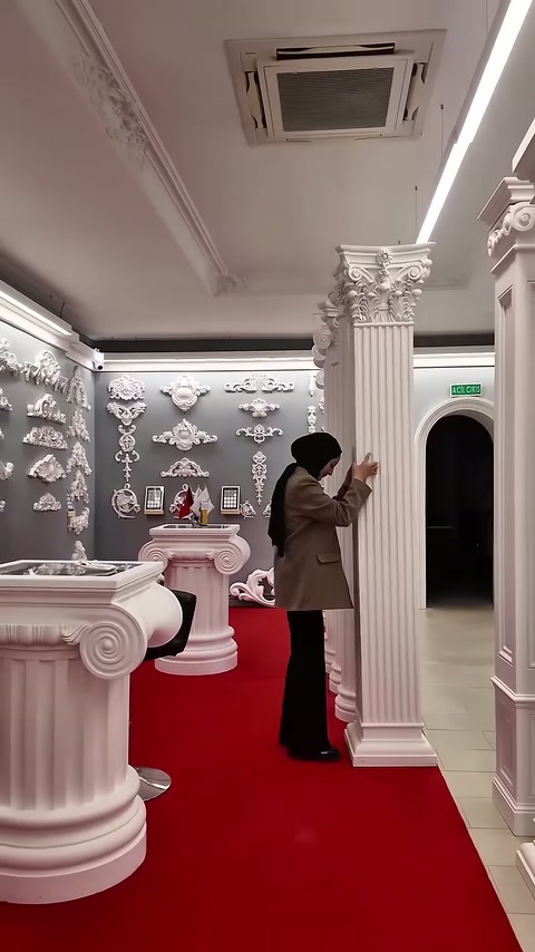 Colonna alta con capitello lavorato esposta davanti ad altri modelli