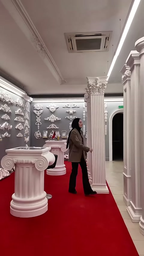 L'addetto tocca la sezione del capitello ornamentale della colonna scanalata