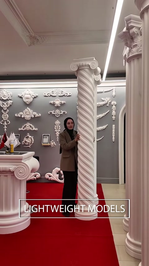Twisted classical column stands among capitals and ornamental wall details.