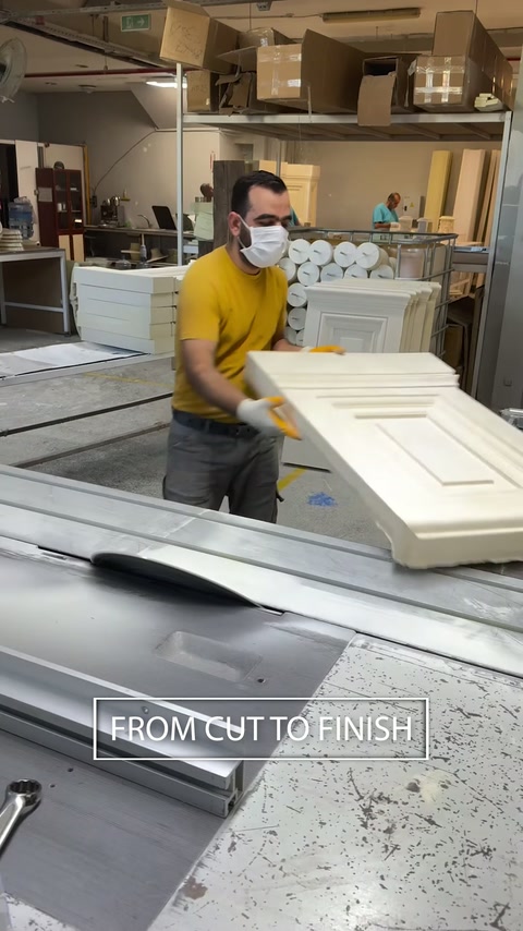 Workshop technician shapes a paneled polyurethane pedestal component.