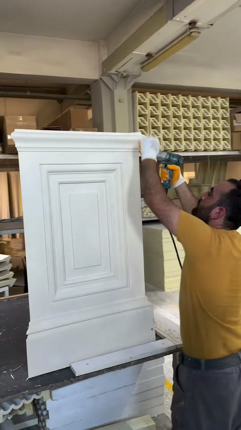 Two technicians align the upper section during decorative pedestal assembly.