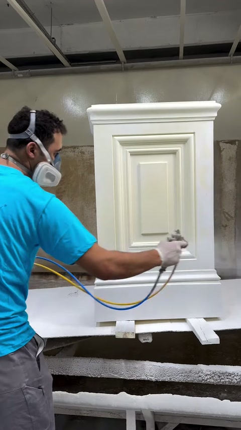 Technician applies an even surface coating to a decorative pedestal.