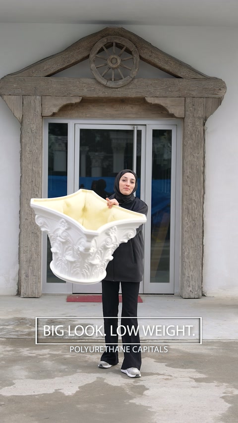 Woman carries an oversized Corinthian capital outside with minimal effort.
