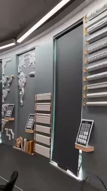 Long cornice sections on a showroom wall are viewed from a diagonal angle