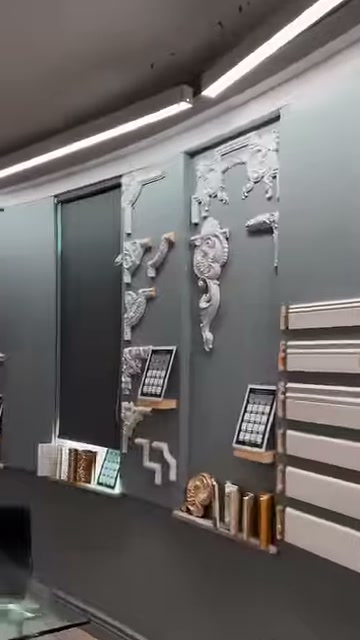Corner motifs and short profile pieces are displayed on an illuminated wall