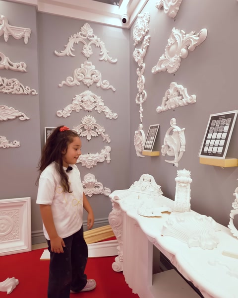 Esposizione raggruppata di cornici e rosoni decorativi su parete