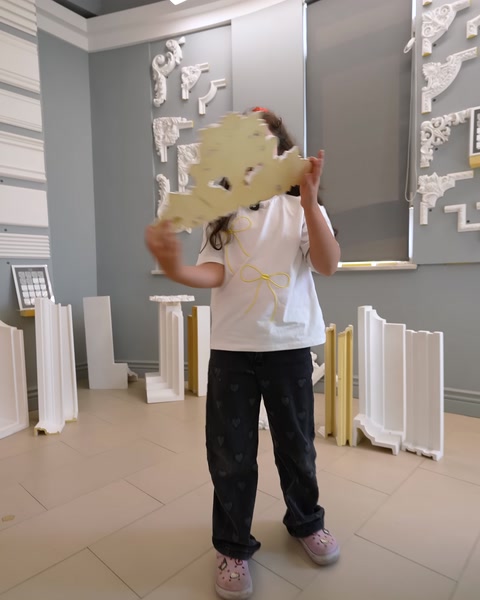 Bambina che tiene in mano grande prodotto rosonico per decorazione soffitto