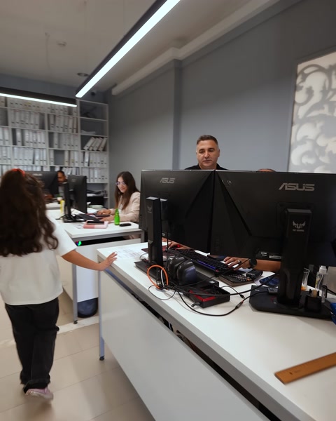 Scrivania reception con schermi computer e personale al lavoro