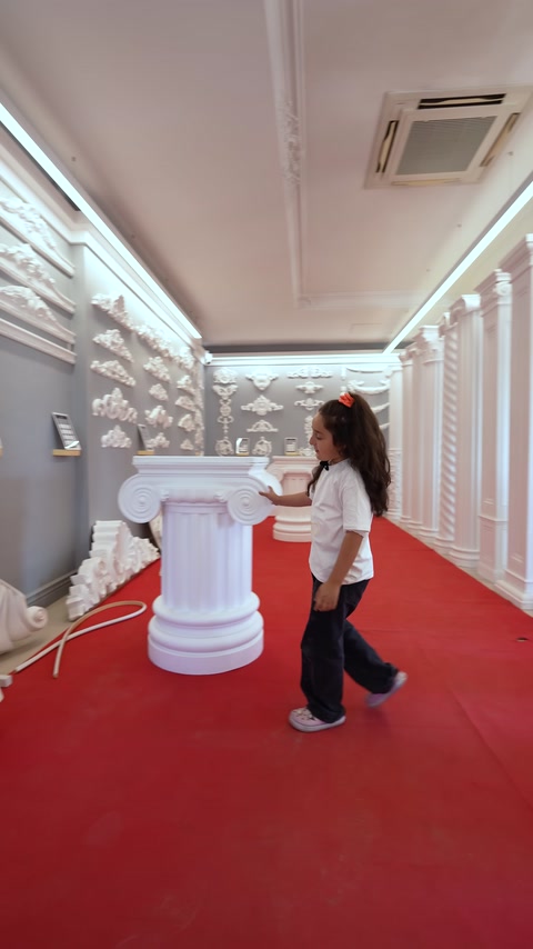 Motivi da parete, una base per colonna e una scultura decorativa sono esposti insieme.