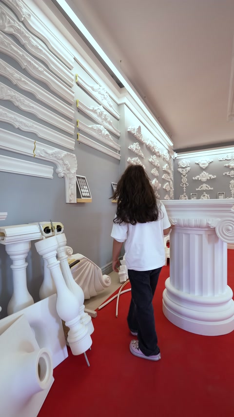 La presentatrice esamina da vicino la sezione showroom con campioni di profili.