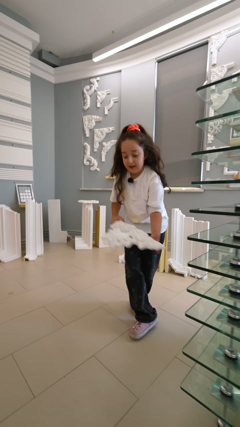 La presentatrice espone l'elemento decorativo davanti a diverse sezioni di profili.