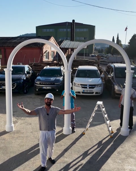 Technician presenting assembled white arch modules in the outdoor yard