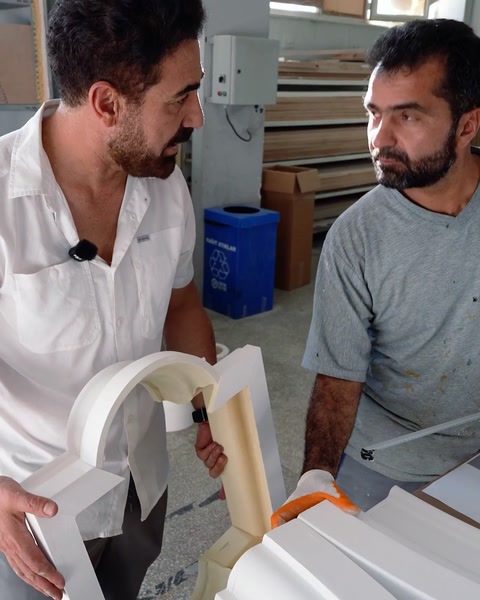 Craftsmen inspecting a curved arch segment before assembly
