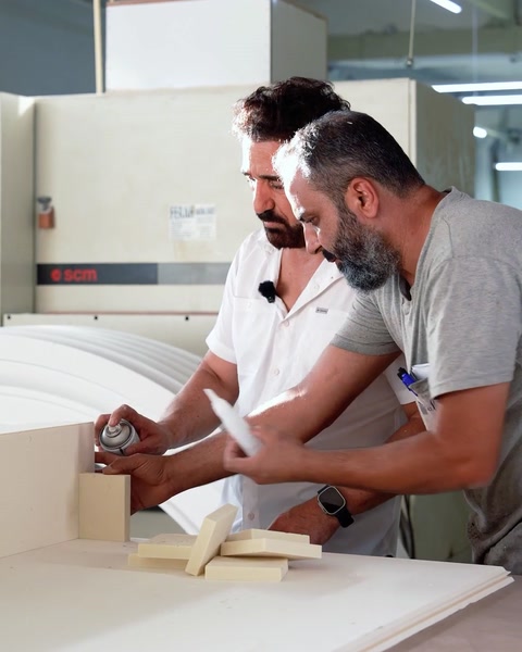 Worker applying adhesive to a column element in production