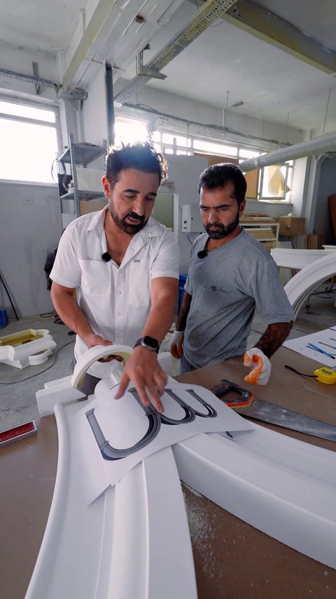 Squadra che controlla sagome d'arco e disegni di profilo sul banco da lavoro