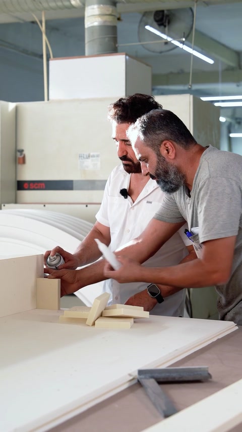 Operaio che applica l'adesivo su un elemento di colonna in produzione