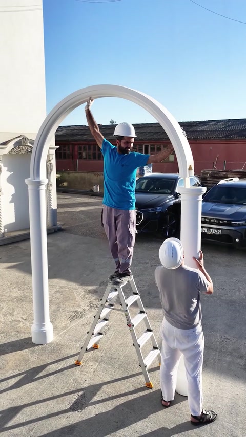 Operaio su una scala che unisce l'arco alla testa della colonna